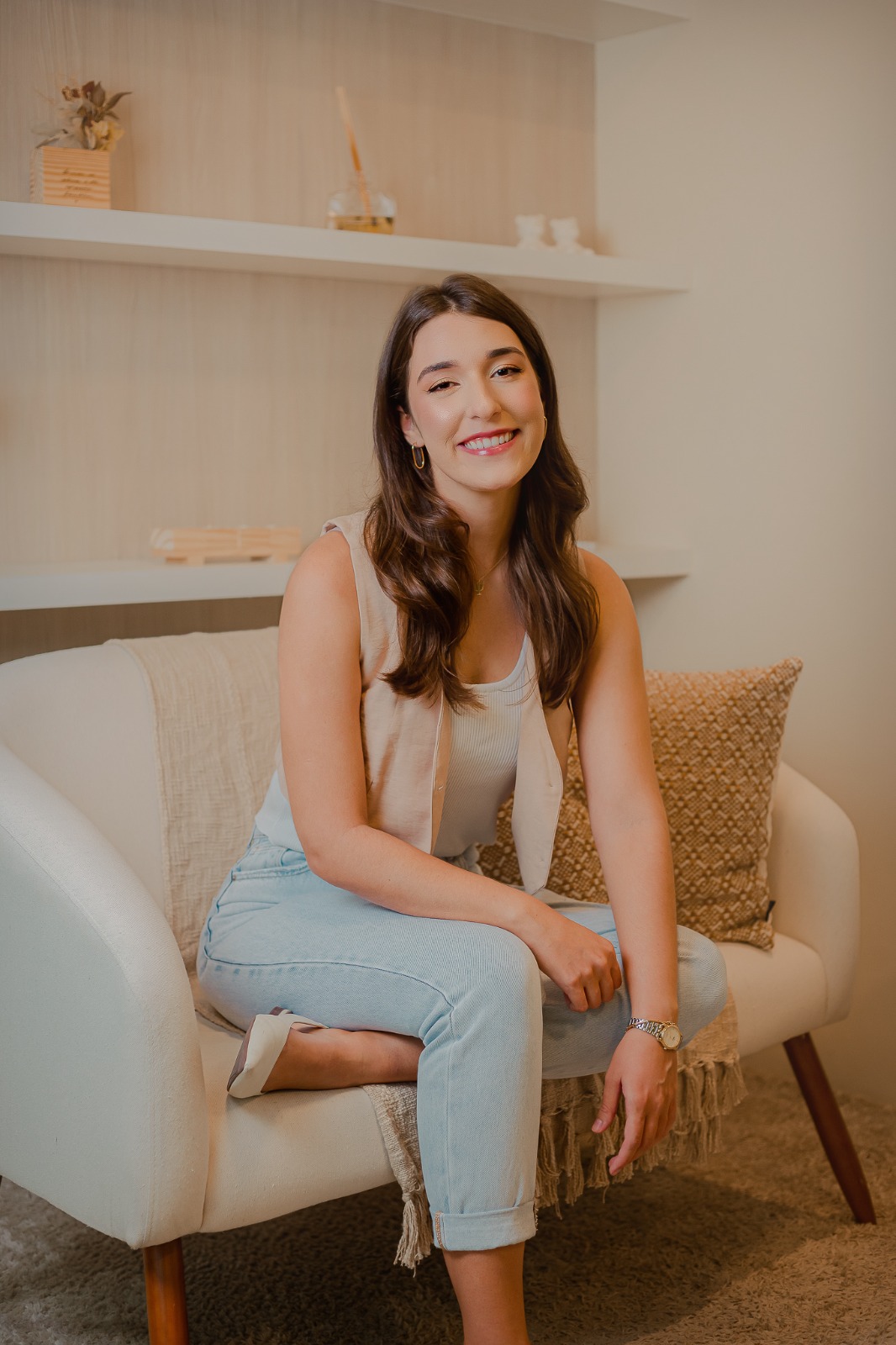 Amanda de Hollanda Winkler, psicóloga clínica, sentada em uma poltrona e sorrindo